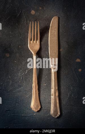 Elegant cutlery. A fork and a knife on a black slate background Stock Photo