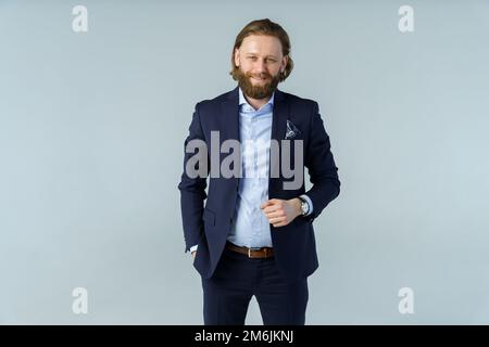 A handsome brutal bearded and long-haired man, a stylish businessman on a white background Stock Photo