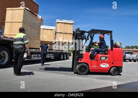 Rigging technicians unload a coordinate measuring machine (CMM) from a tractor trailer at Fleet Readiness Center East (FRCE). A CMM is a device that measures the geometry of physical objects by sensing points on the surface of the object with a probe. This machine is one of two new CMMs FRCE acquired capable of large-volume measurement. Depot officials say these additional machines will improve efficiency and reduce wait times caused by maintenance and equipment calibration. (Photo by Joe Andes, Fleet Readiness Center East Public Affairs.) COMFRC,FRCE,NAVAIR,USNAVY, Stock Photo
