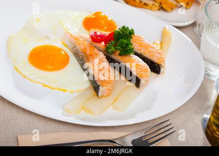 Fried salmon with scrambled eggs and asparagus Stock Photo