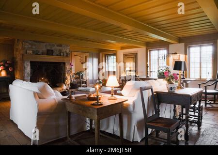 White cloth upholstered sofas in living room inside old 1752 French regime cottage style home. Stock Photo