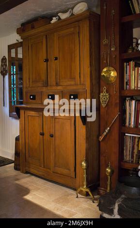 Handmade brown stained antique wooden buffet in kitchen inside old 1809 cottage style home. Stock Photo