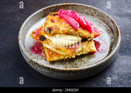 Traditional roasted Italian panettone tiramisu with vanilla custard curd and rhubarb served as close-up in a Nordic design bowl Stock Photo