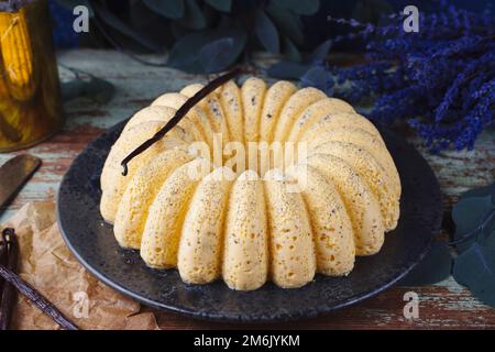 Traditional Italian steamed egg milk cream vanilla pudding in bundt cake shape served as close-up on a Nordic design plate with Stock Photo