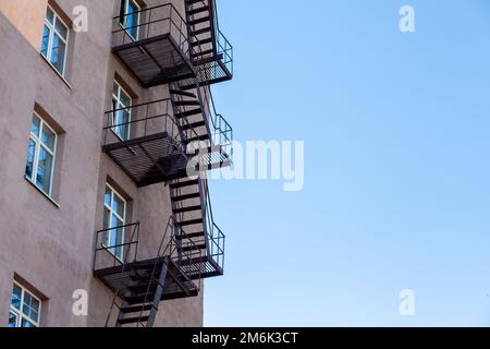 Silhouette of a fire escape on a high-rise building against a blue sky Stock Photo