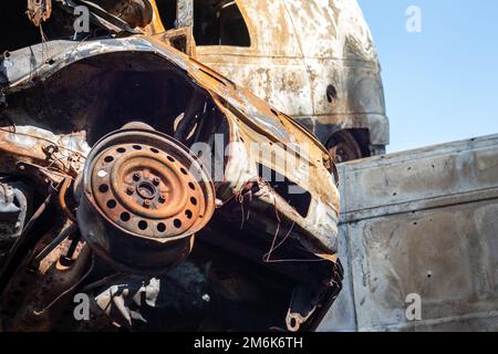 Broken and burned cars in the parking lot, accident or deliberate vandalism. Burnt car. Consequences of a car accident. Damaged Stock Photo
