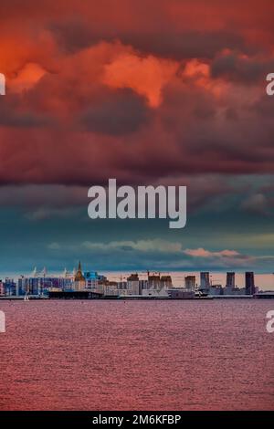 Magic pink sky over the residential complex under construction on the embankment of the Neva River on Vasilievsky island in suns Stock Photo