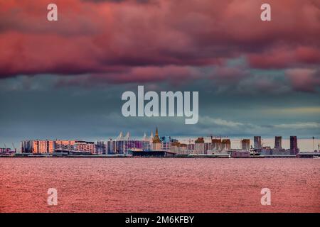 Magic pink sky over the residential complex under construction on the embankment of the Neva River on Vasilievsky island in suns Stock Photo