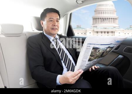 Business man reading a newspaper in the sitting car Stock Photo