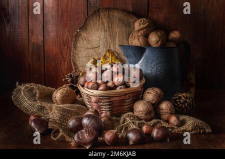 Hazelnuts in a basket and other nuts on a dark wooden background Stock Photo