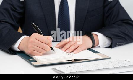 Hands of a businessman writing a schedule or recording ideas in a diary Stock Photo