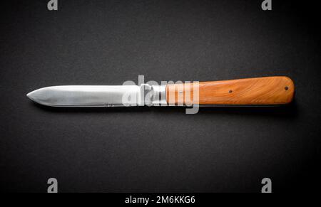 Traditional wooden pocket knife on black background Stock Photo