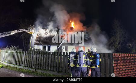 05 January 2023, North Rhine-Westphalia, Emsdetten: Firefighters extinguish the fire in a house. A fire has destroyed a residential house in the district of Steinfurt. The 85-year-old resident of the building noticed the fire, called the fire department and escaped unharmed to safety, police said Thursday. According to initial estimates, the damage amounts to 200,000 euros. The cause of the fire was initially unclear. Photo: Nord-West-Media TV/dpa Stock Photo