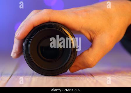 chinese 50mm lens in hand on table and colored background Stock Photo