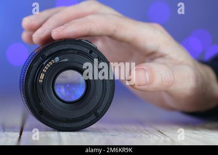 the back of the chinese lens with a chip on the table and a colored background Stock Photo