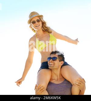 The view is really nice from up here. A woman posing playfully while perched on her boyfriends shoulders. Stock Photo
