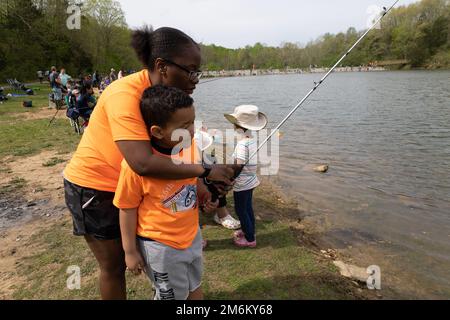 Staff Sgt. Kierra Magee, material manager, 1st Theater Sustainment Command, fishes with her 6-year old son, Jarin, at a fishing derby held April 30, 2022 at Military Park Fort Knox Camp Carlson. The event was hosted by Fort Knox Morale, Welfare and Recreation and Vine Grove Veterans of Foreign Wars Post 10281. Stock Photo