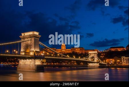 Royal Palace or the Buda Castle and the Chain Bridge after sunset in Budapest in Hungary. Stock Photo