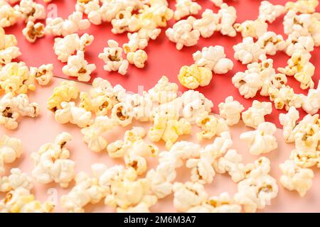 Tasty popcorn scattered on color background, closeup Stock Photo