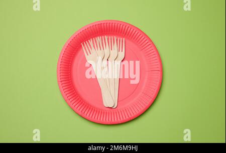 Wooden fork and empty round red disposable plate Stock Photo