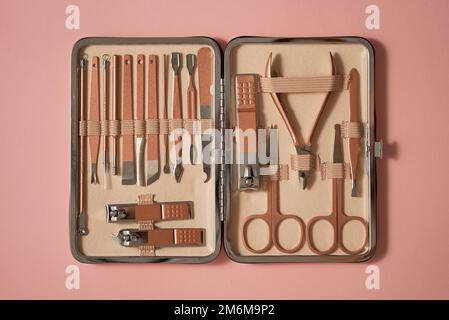 Pastel cosmetic set for nail care in a case placed on a pink background Stock Photo