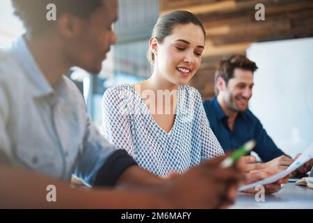 Sharing her ideas for the project. two coworkers discussing documents during a meeting. Stock Photo