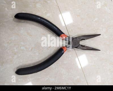 old rusty black pliers tool isolated on a the surface Stock Photo