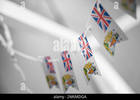 A garland of British Antarctic Territory national flags on an abstract blurred background. Stock Photo