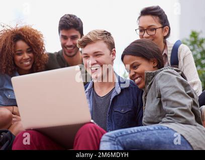 Your answer is a click away. a group of students sitting outside while on campus. Stock Photo
