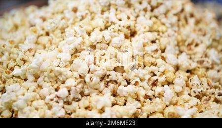 Scattered salted popcorn, Texture background. Film and cinema concept, popcorn selling in popcorn machine, popcorn behind the glass in a machine, Popc Stock Photo