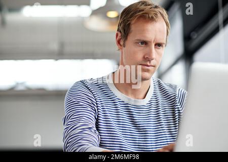Hard work gets him results. a man working on a laptop in an office. Stock Photo