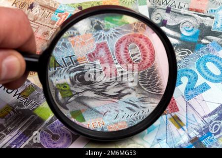 Kuwaiti dinar in a magnifying glass a business background Stock Photo