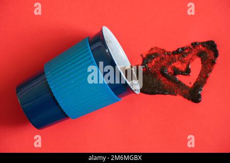 cup lies on a red background with spilled coffee Stock Photo
