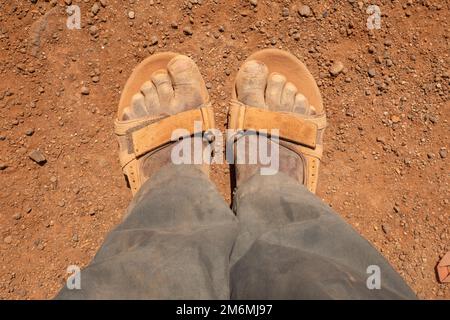 Lower section of a man wearing dirty shoes in Chalbi Desert in Kenya Stock Photo
