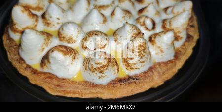 Lemon meringue pie over dark background. Selective focus Stock Photo