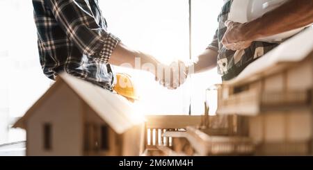 Architect and engineer construction workers shaking hands while working for teamwork and cooperation concept after finish an agreement in the office Stock Photo