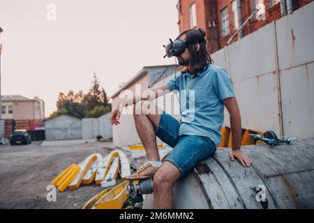 Man pilot controlling quadcopter drone with remote controller pad Stock Photo