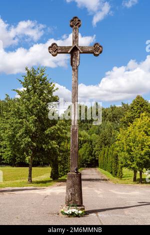 Old wooden cross at entrance to the cemetery Stock Photo