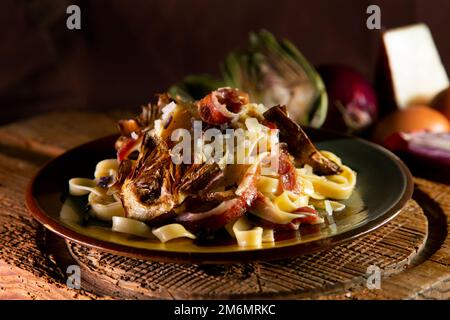 Tagliatelle with artichokes and iberico ham from spain. Stock Photo