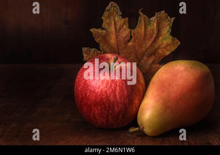Apples and pears in bulk on a dark wooden background in a rustic style Stock Photo