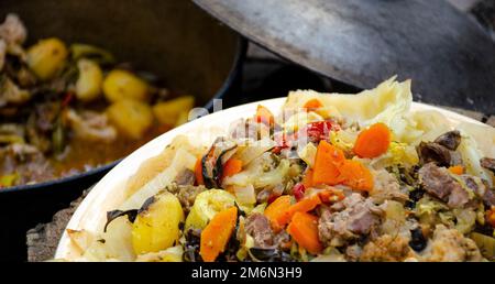 Dimlama on a platter. Uzbek cuisine. Vegetables cooked in their own juice in a cauldron over a fire. Cooking in nature. Healthy food Stock Photo
