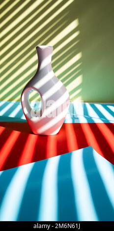 White vase and white flower on abstract striped multicolor background Stock Photo