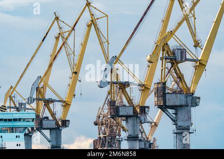 Construction cranes of the shipyard on the Neva River in St. Petersburg in cloudy weather Stock Photo