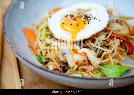 Yakisoba noddles with shrimps and egg on the top. Literally 'fried noodles', integrated into Japanese cuisine, just like ramen. Stock Photo