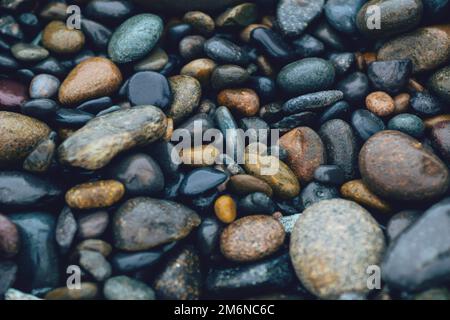 Wet beach pebbles of various colours and sizes Stock Photo