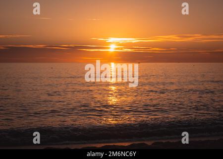 Sunset sun over horizon at sea in out of focus Stock Photo