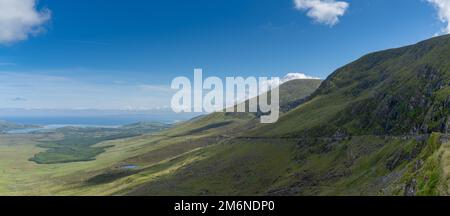 Panorama landscape with the steep and winding mountain road leading to the top of Connor Pass on the Dingle Peninsula in County Stock Photo