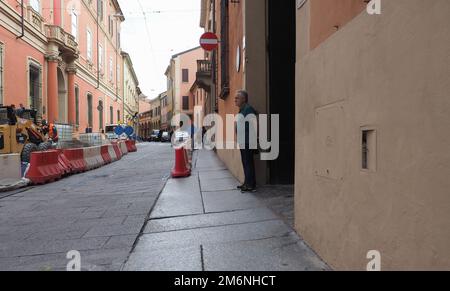 BOLOGNA, ITALY - CIRCA SEPTEMBER 2022: Umarell man of retirement age watching roadworks construction site with hands clasped behind his back and offer Stock Photo