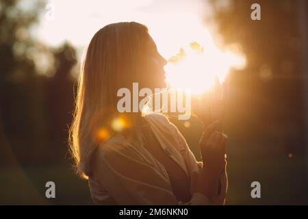 Happy young woman holds fall leaves in hand at autumn park Stock Photo