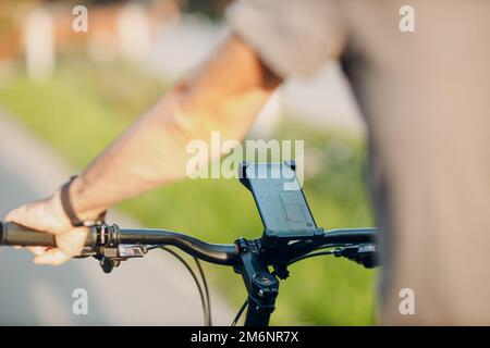Man planning route using GPS navigation application in mobile phone on his bicycle bike. Stock Photo